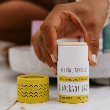 A lady holing a tube of Lemongrass, lime & Patchouli deodorant balm for sensitive skin