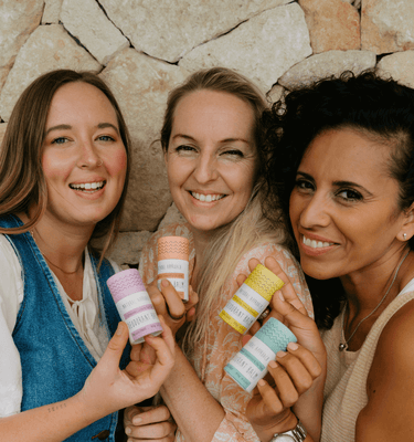 Three women holding eco-friendly deodorant push-up tubes in Natural Approach's sensitive skin range.