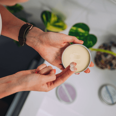 A lady scooping out some Natural Approach deodorant balm from a 50g tin of deodorant